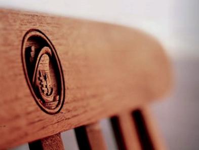Una de las sillas exteriores de madera de teca con el escudo de la Holland America
